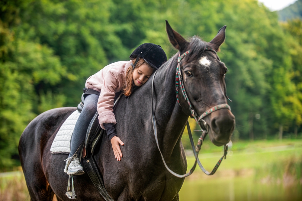 A kid enjoying ride on a horse